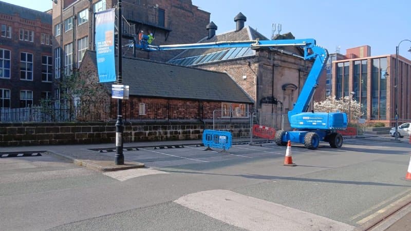Blue articulated boom lift working on a site in Liverpool