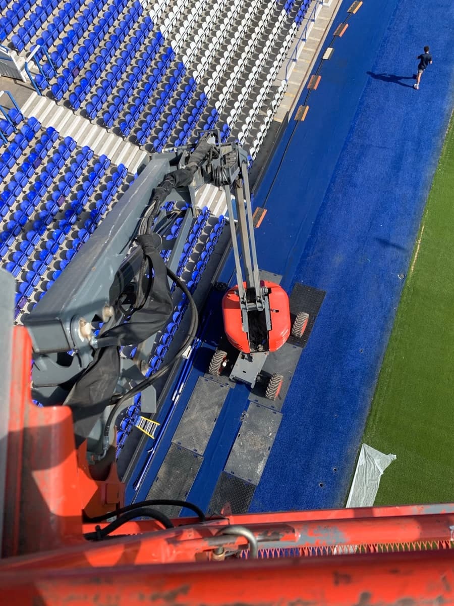Elevated boom lift access beside football stadium seating in Birmingham