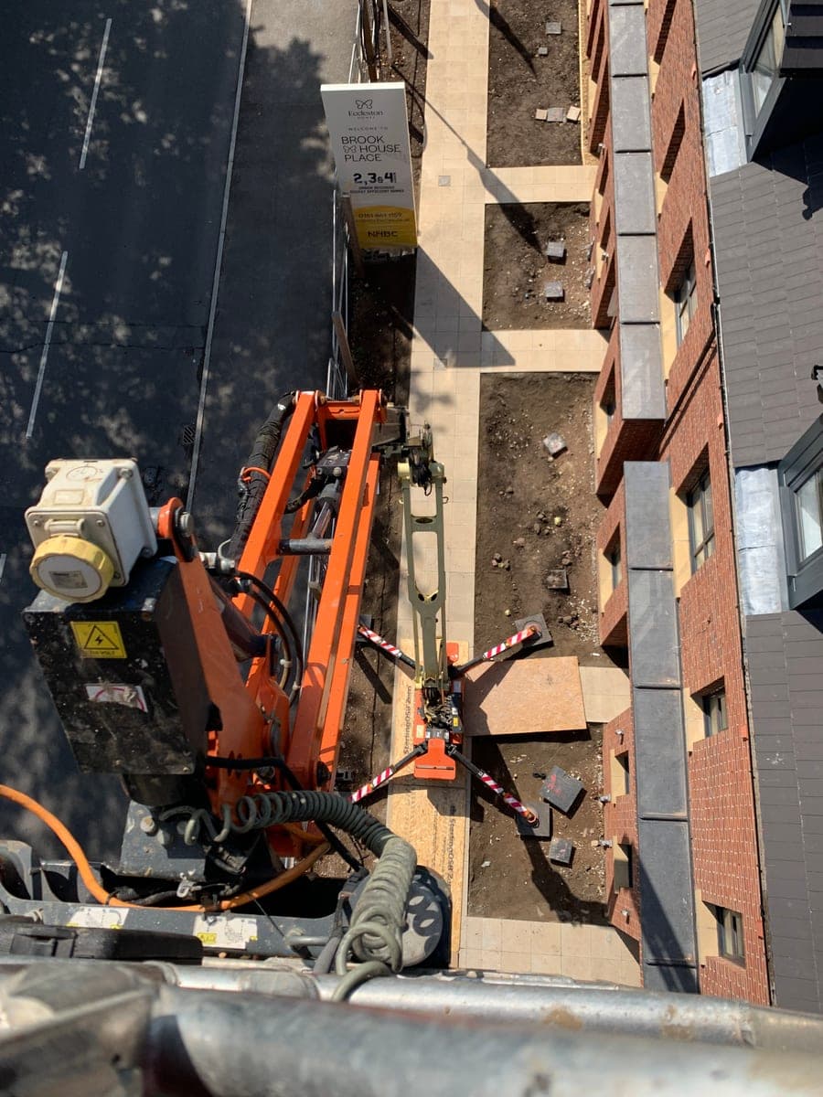 Elevated view down the spider-lift boom alongside the frontage of new homes