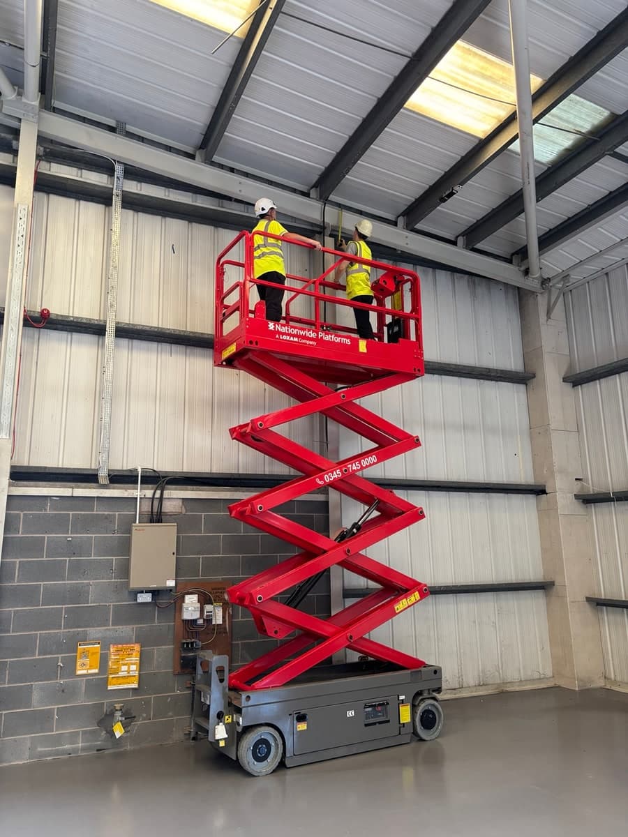 Engineers measuring structural steelwork from a scissor lift in Warrington